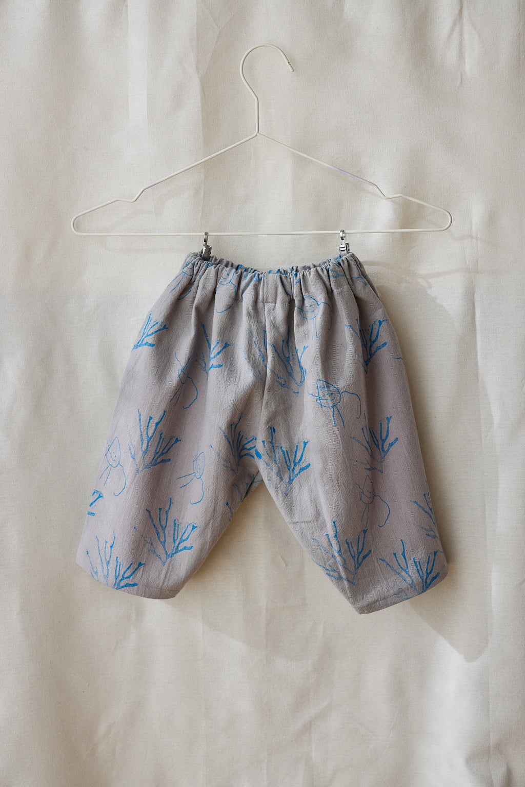 Pantalón gris claro estampa azul.