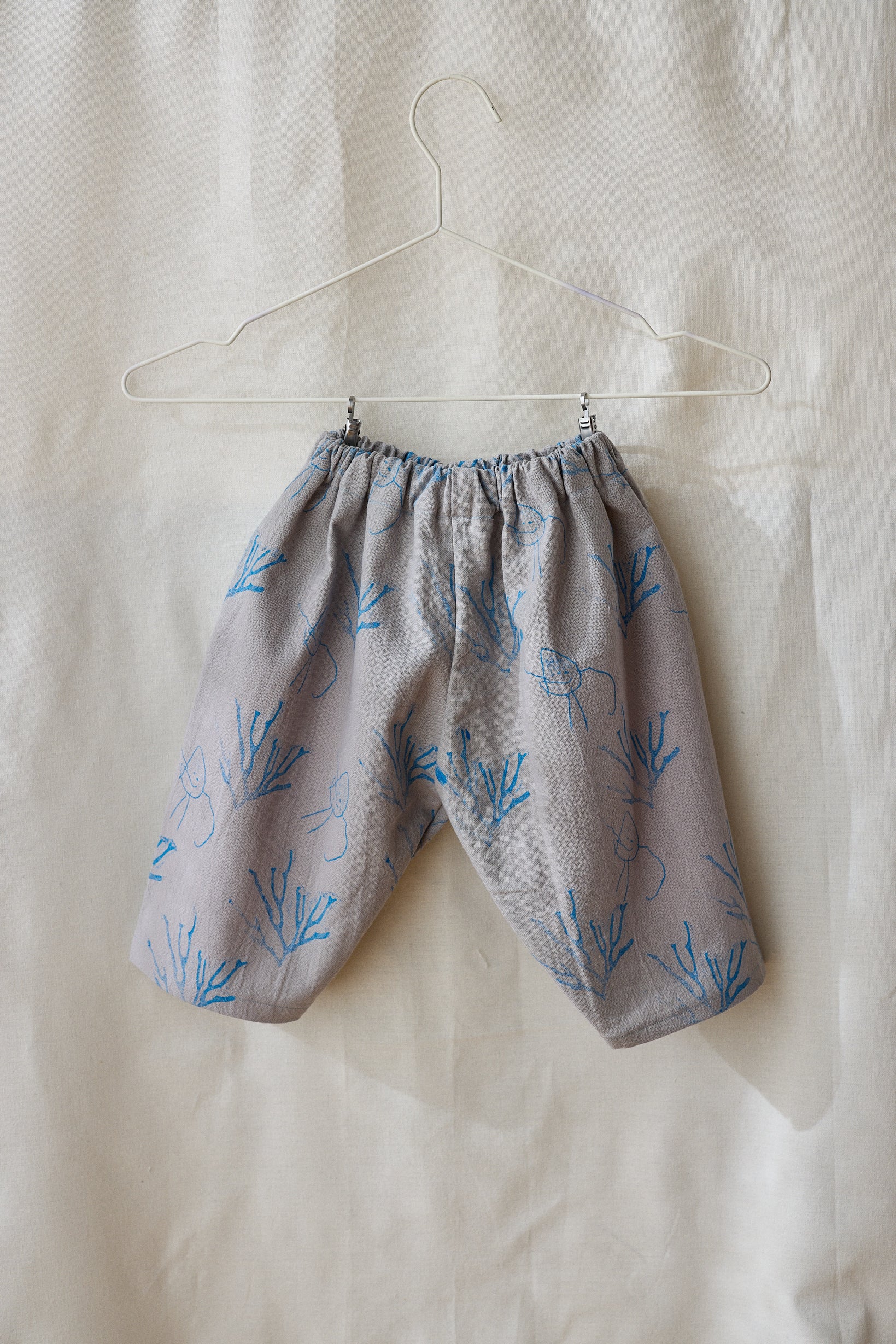 Pantalón gris claro estampa azul.