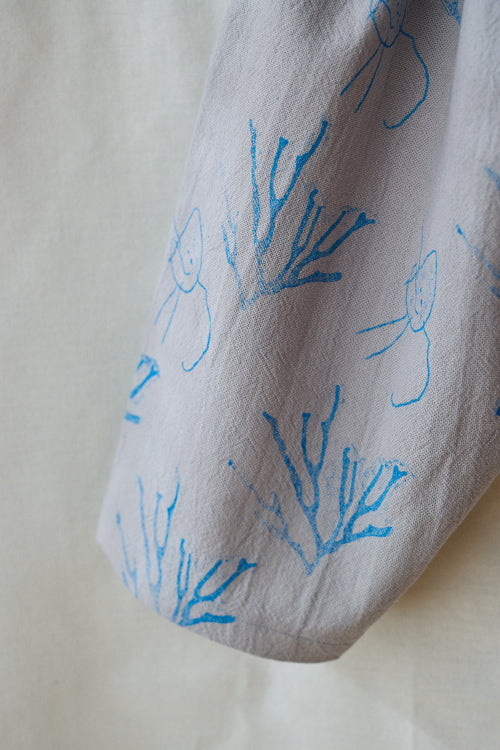 Pantalón gris claro estampa azul.